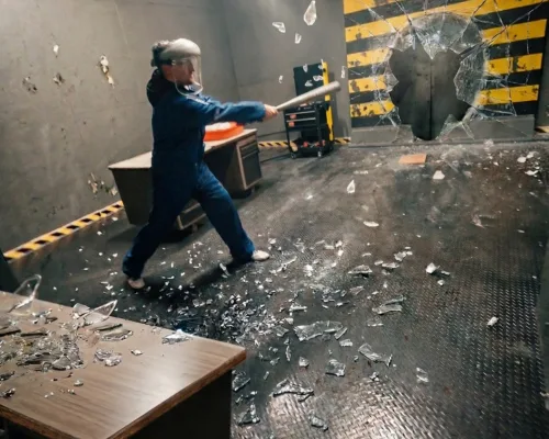 Guest swinging at a target as glass shatters in the Smash Room